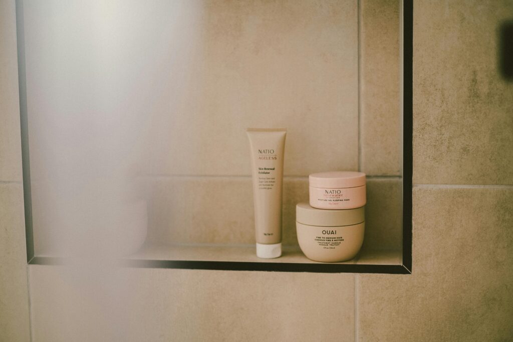A modern bathroom shelf featuring beauty and self-care products in a minimalist style, perfect for self-care routines.